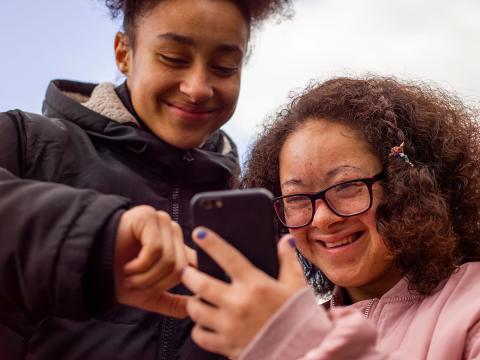 Two girls with a mobile phone. 